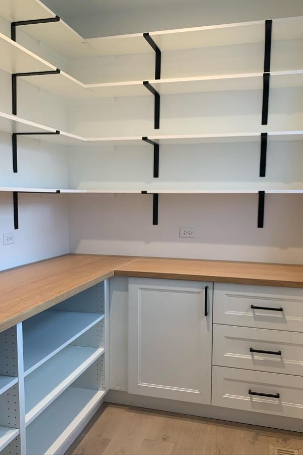 Sleek open shelving featuring modern black brackets in kitchen.