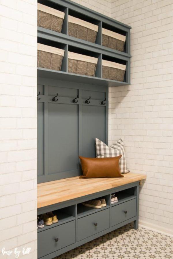 Sage green mudroom storage unit from House by Hoff with wicker baskets and wooden bench top.