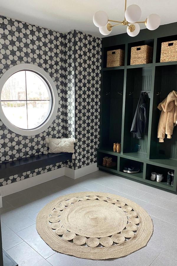 Forest green built-in lockers from @laurenelizabethburke. Features geometric wallpaper and circular window with storage compartments.