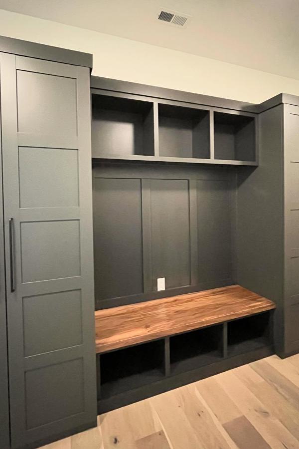 Sage green mudroom storage unit from @carolinareclaimed. Features wooden bench and multiple compartments for organization.