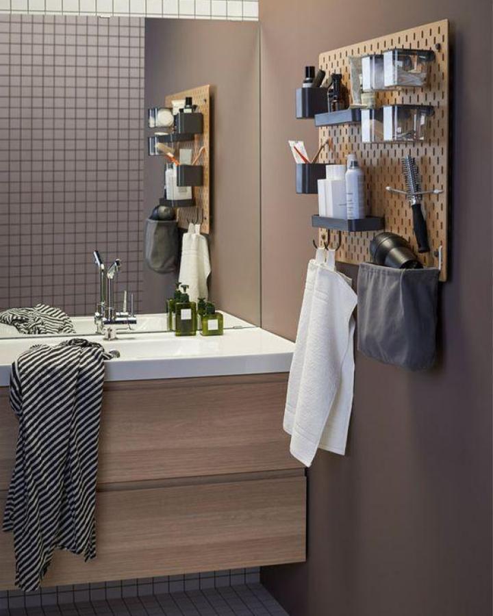 Natural wood bathroom pegboard setup showcasing ikea skadis pegboard hacks & ideas with black storage containers and towel hooks.