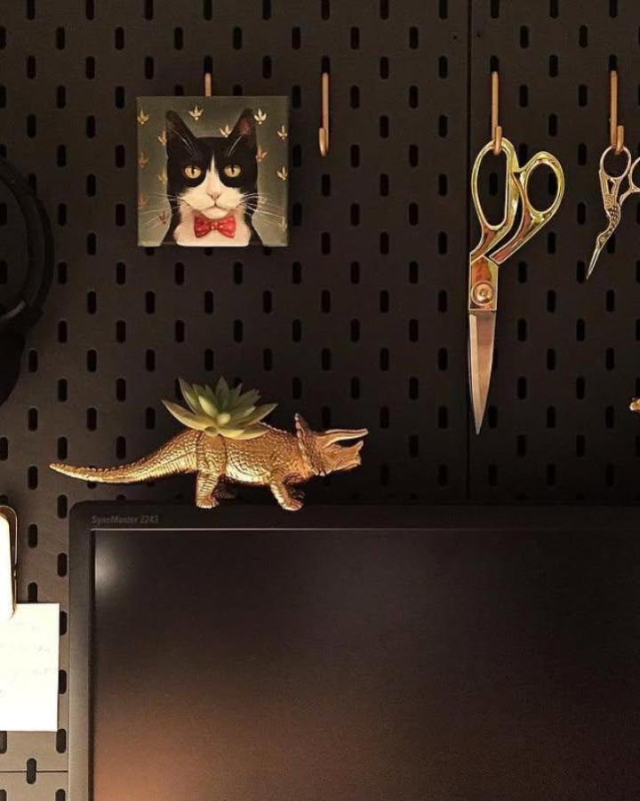 Dark pegboard workspace featuring ikea skadis pegboard hacks & ideas with copper accessories and cat artwork from @foxyandbrass.