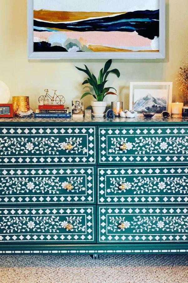 Teal painted dresser with intricate white Moroccan-style patterns from @gingerandivory. Hand-painted geometric and floral designs on each drawer.