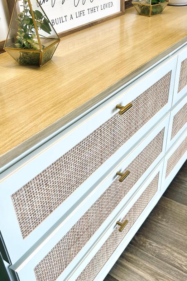 White Malm dresser with natural woven cane panels from @now.and.then.restorations featuring brass handles and wood top.