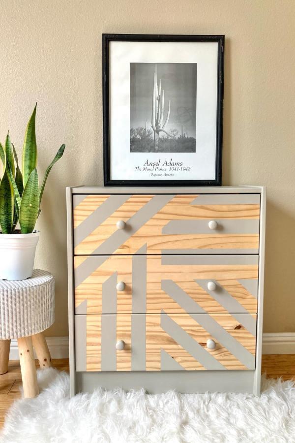 Wood grain contact paper dresser makeover from @furniture_refurbitch. Features diagonal gray tape geometric pattern design.