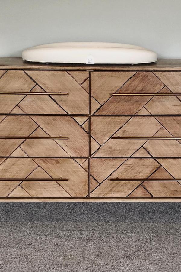 Natural wood geometric dresser makeover from @refinedandcompany. Chevron and diamond patterns transform basic furniture piece.