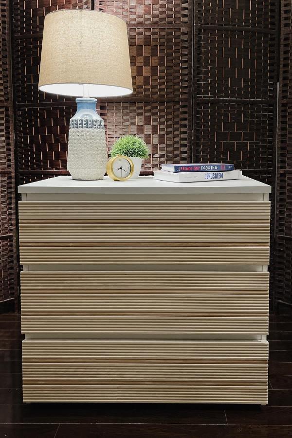 Textured white dresser from @usonaroll showcasing creative ikea dresser hacks & ideas with horizontal wood strips.