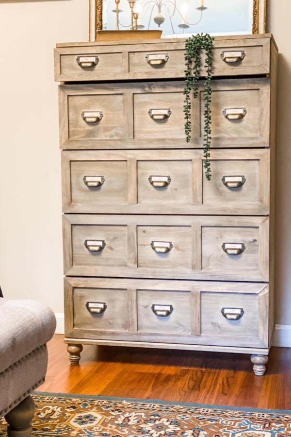 Weathered wood dresser with brass hardware and decorative legs from @mydiyfarmhouse. Vintage card catalog aesthetic.
