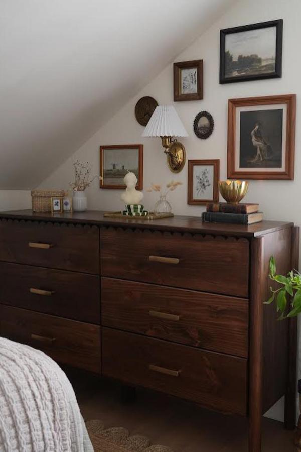 Dark wood-stained dresser with brass handles from @diydanie. Gallery wall and vintage accessories complete the look.