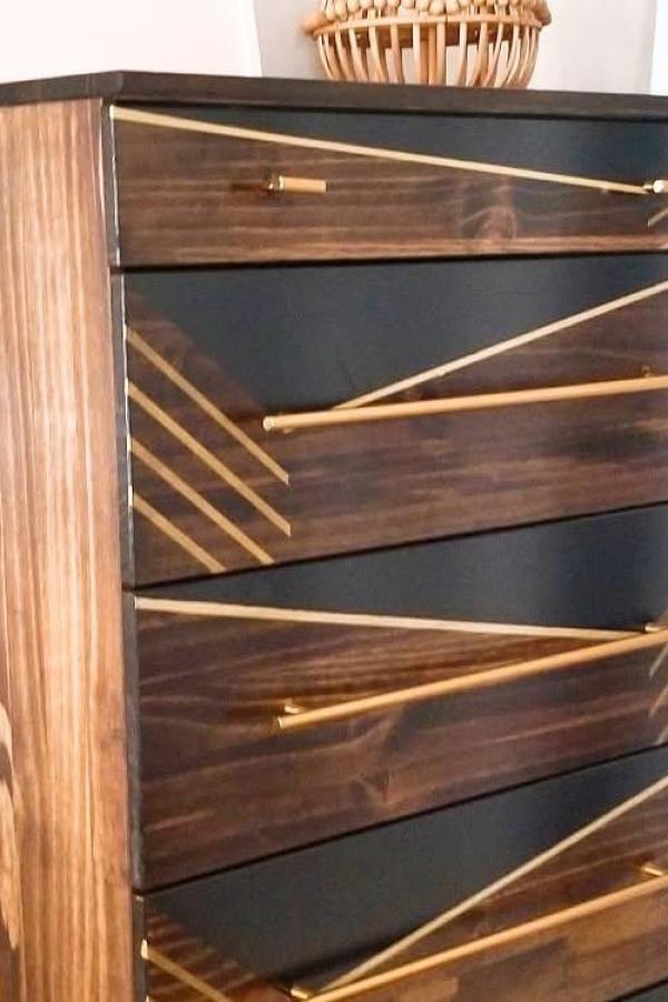 Modern geometric dresser makeover from @andreapalmai featuring dark paint and diagonal wood strip pattern.