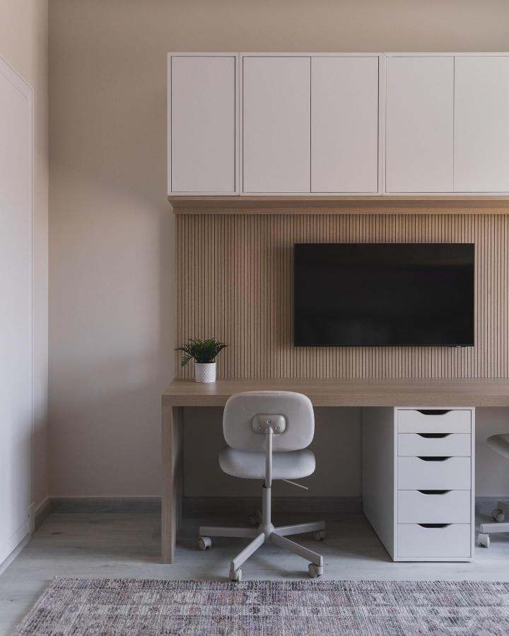 Minimalist workspace featuring white wall-mounted cubes showcasing ikea eket hacks & ideas with fluted wood backdrop.