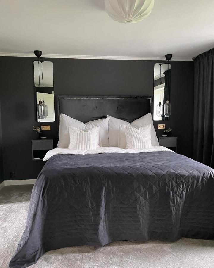 Charcoal floating nightstands from @hannarodin. Wall-mounted EKET cubes beside bed with pendant lighting.