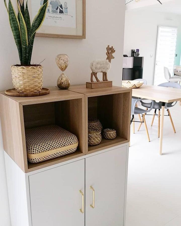 Two-tone wooden and white cube storage unit from @coupsdecoeurs.deco featuring brass handles and decorative styling.