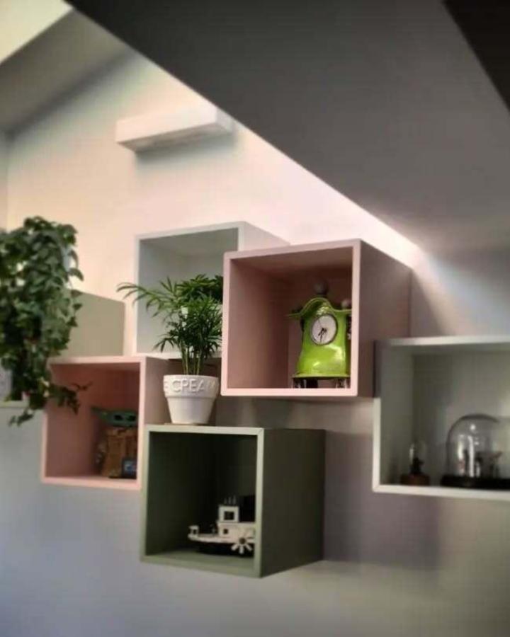 Pink and green painted wall cubes from @matthew_job_done_ramsbottom. Creative storage display with plants and decorative items.