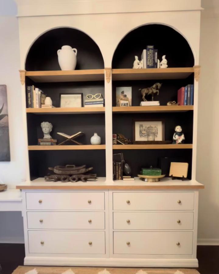 White built-in bookcase with black painted arched interiors showcasing ikea arched bookcase hacks & ideas from @kellbellcan.