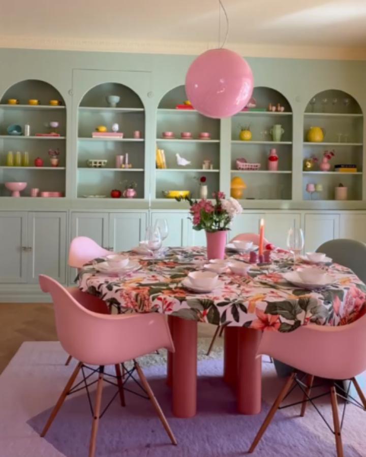 Sage green built-in dining room storage from @kinevinje displaying colorful ceramics and glassware.