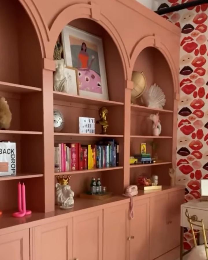 Coral pink built-in bookcase from @dreamloftstudios. Custom arched openings showcase books and decorative objects beautifully.