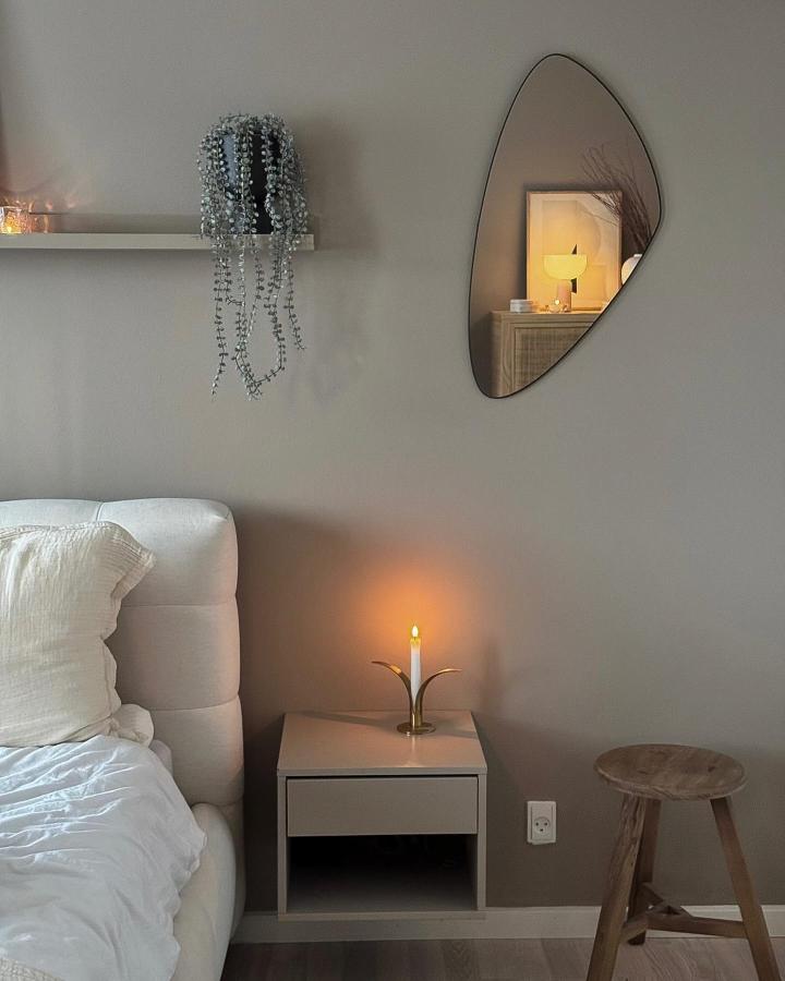 Minimalist bedroom corner from @home_by_juul with trailing plant on floating shelf above modern nightstand.