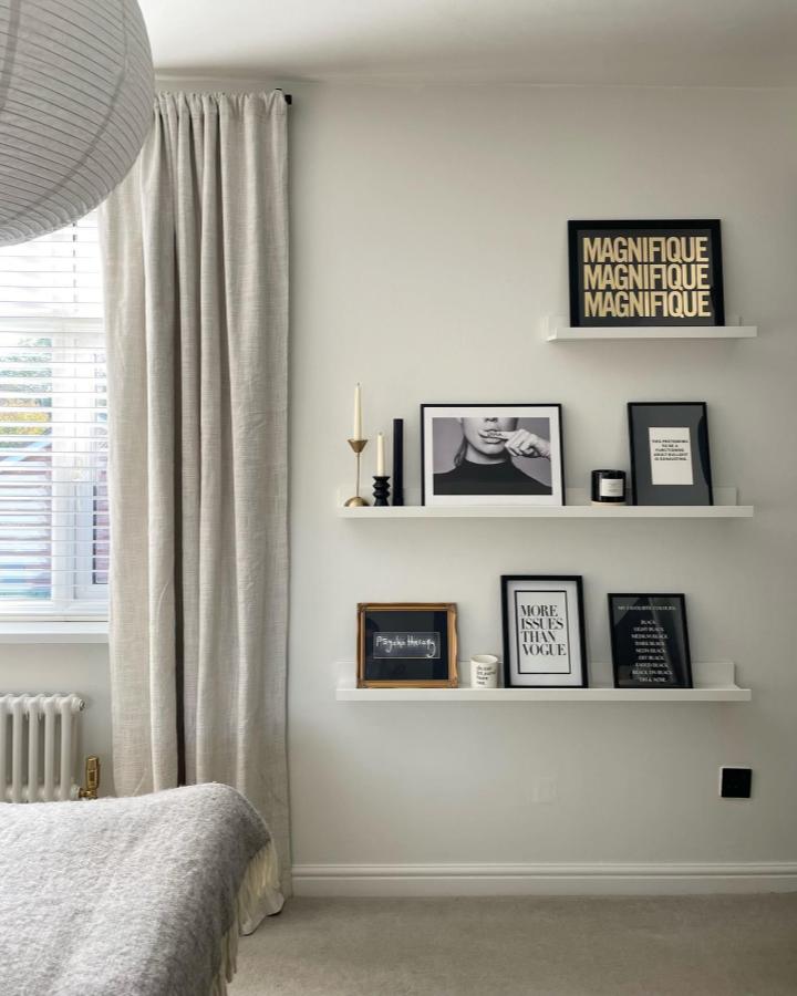 Minimalist bedroom wall display showcasing ikea mosslanda ideas from @helenmclean.curated with layered black frames and decor accessories.