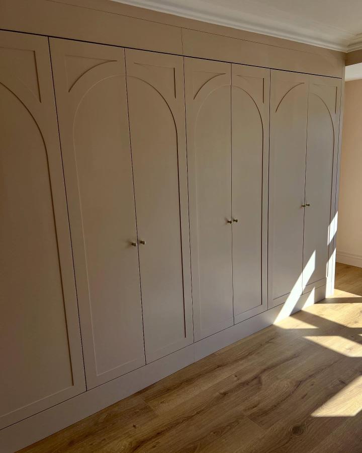 White wardrobe with arched door panels and brass knobs from @the_pax_man in sunlit bedroom