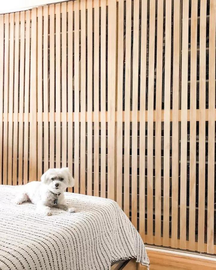 Natural wood slat wardrobe doors with vertical spacing from Hygge Spruce creating modern bedroom storage texture