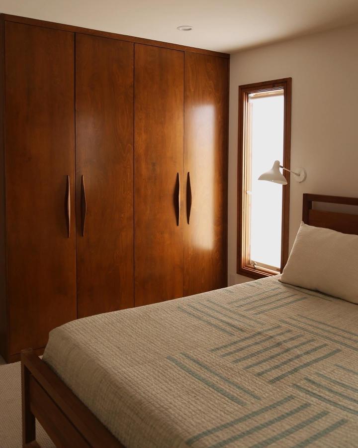 Rich wood veneer wardrobe doors with vertical handles in bedroom from @intentionallyhope featuring best ikea pax wardrobe hacks & ideas with natural lighting