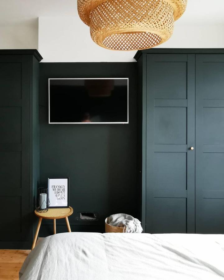Deep forest green paneled wardrobe and bedroom walls from @number_twentyseven featuring best ikea pax wardrobe hacks & ideas with woven pendant lighting