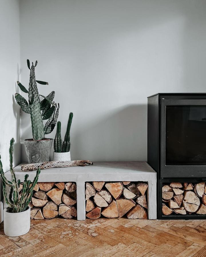 White console table with firewood storage from @heartpledge. Modern TV stand hack with natural wood compartments.