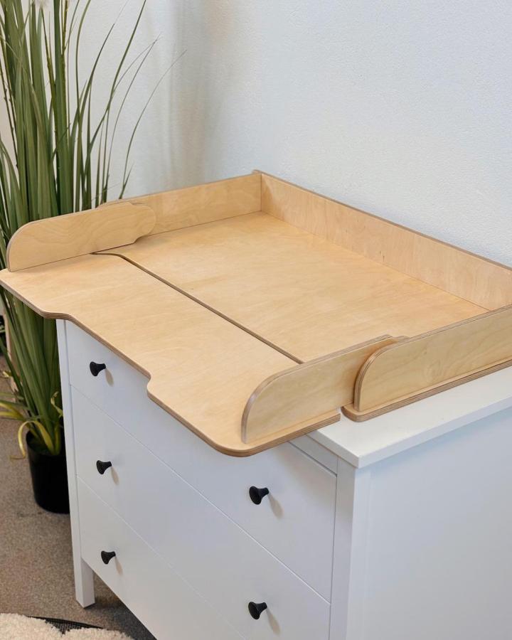 Birch plywood changing station from AdventureLand28 atop white Hemnes dresser with heart-shaped handles.