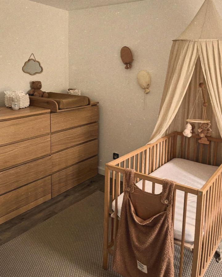 Oak Malm dresser nursery setup from @mariedouillardd. Cream canopy and brown textiles complement the wood.