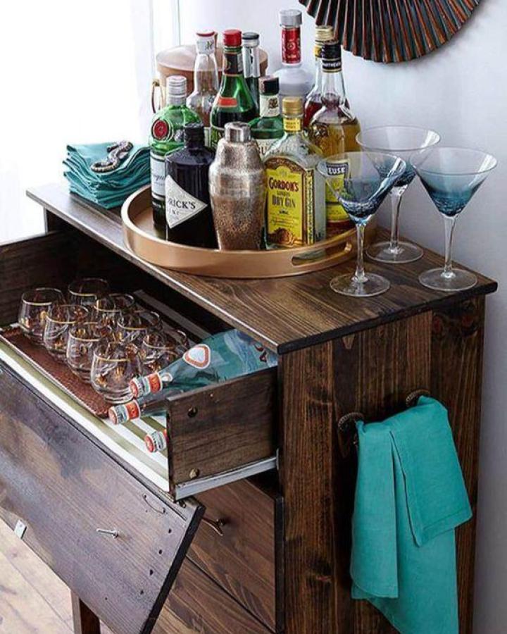 Dark wood Ikea Tarva dresser bar station from Karla Conrad featured on BHG with turquoise accents and glassware storage