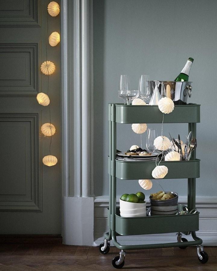 Sage green metal bar cart from @ikeacanada. Decorated with paper lanterns and entertaining essentials.