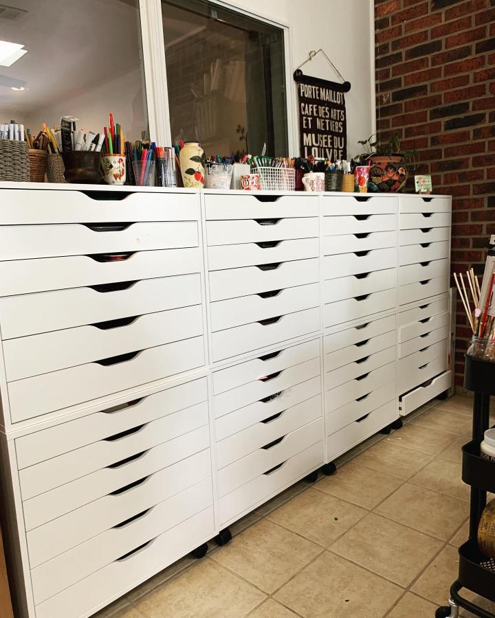 White rolling drawer units from @artbyloriperez. Multiple Alex units with supplies on top against brick wall.