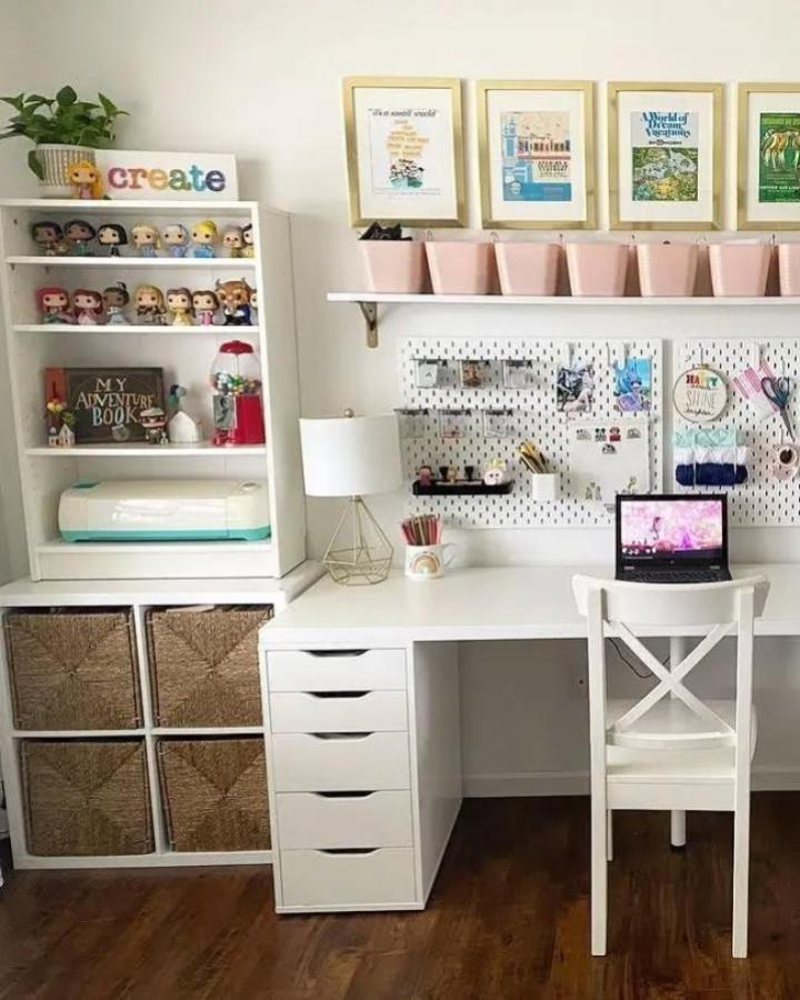 White craft workspace from @smartfundiy with pink storage bins and pegboard organization