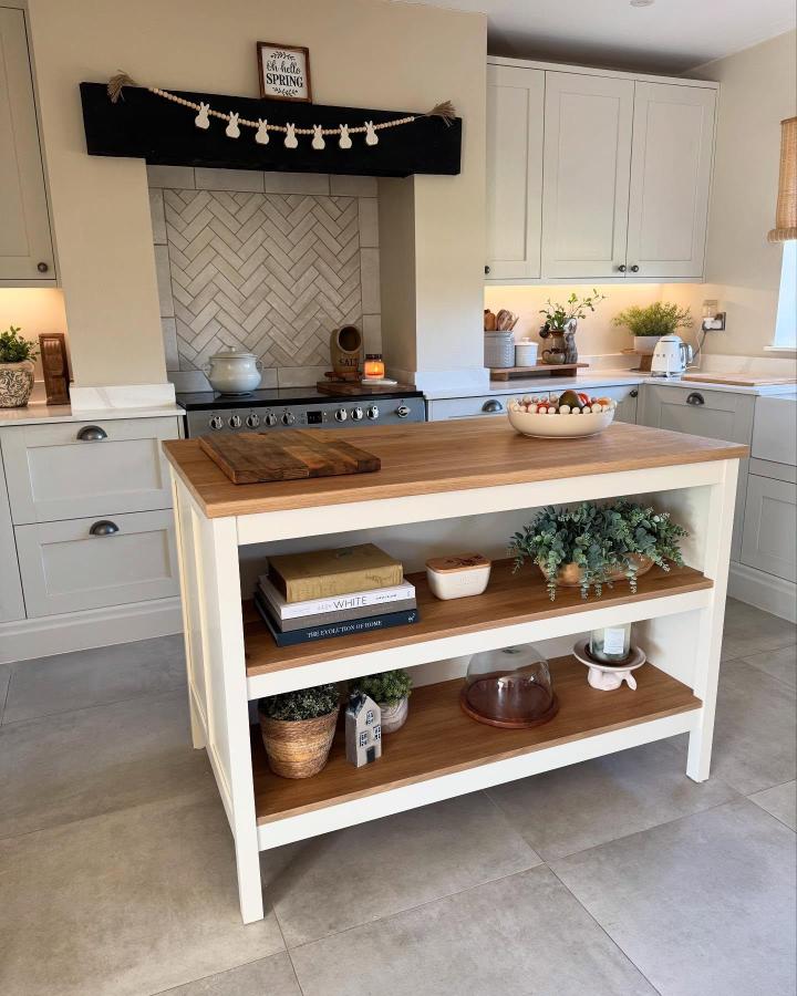 Oak and off-white ikea kitchen island ideas from @orchardrise_cottage featuring open shelving styled with books and plants.