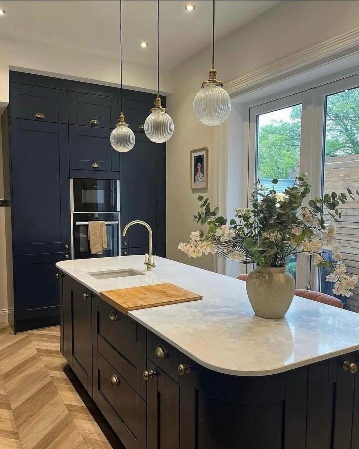 Navy Metod kitchen island from @edwardian_property_parade. Marble countertop with brass hardware and pendant lighting.