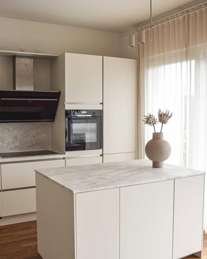 Marble-effect white kitchen island from @_christelle____ . Minimalist design with clean handleless cabinetry