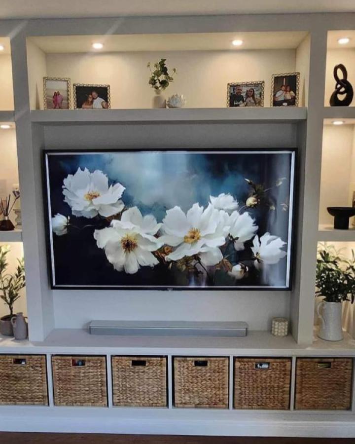 Gray built-in media wall from @aaninteriorsltd. Kallax unit with basket storage and alcove lighting.