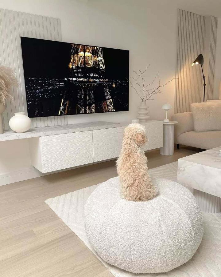 White ribbed floating media console from @rucomfy. Textured cabinet fronts with wall-mounted design beneath mounted television.