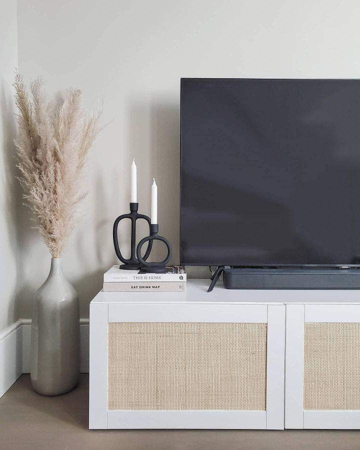 White media console featuring ikea media center hacks & ideas from @styledby.sue with natural cane webbing door inserts.