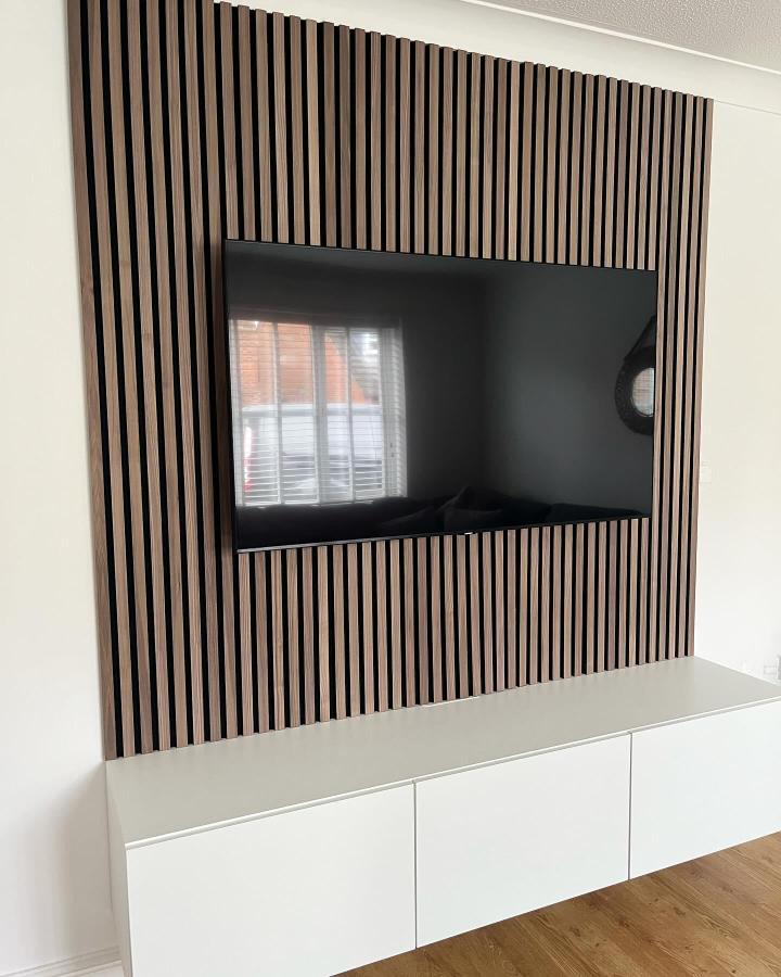 Vertical wood slat accent wall with mounted TV showcasing ikea media center hacks & ideas from @ourhome_themartins.