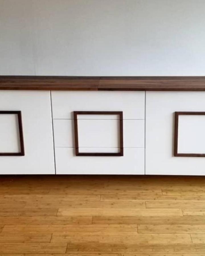 White cabinet with walnut frame detail from @livingstoncabinetry. Geometric square inset on media console.