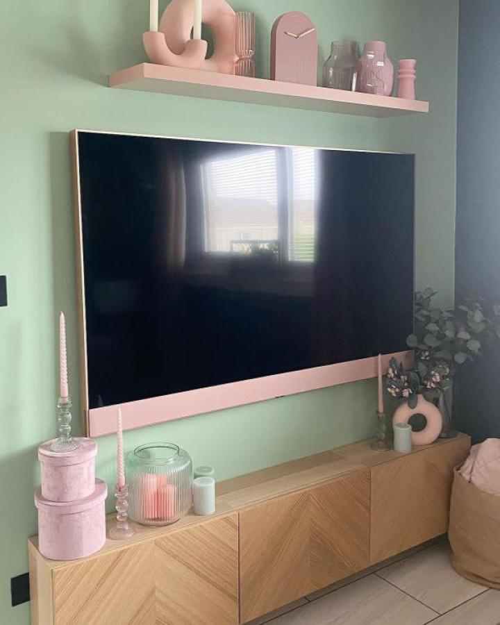 Pastel pink shelf and oak media unit from @the_gaygordons with mint walls and decorative accents.