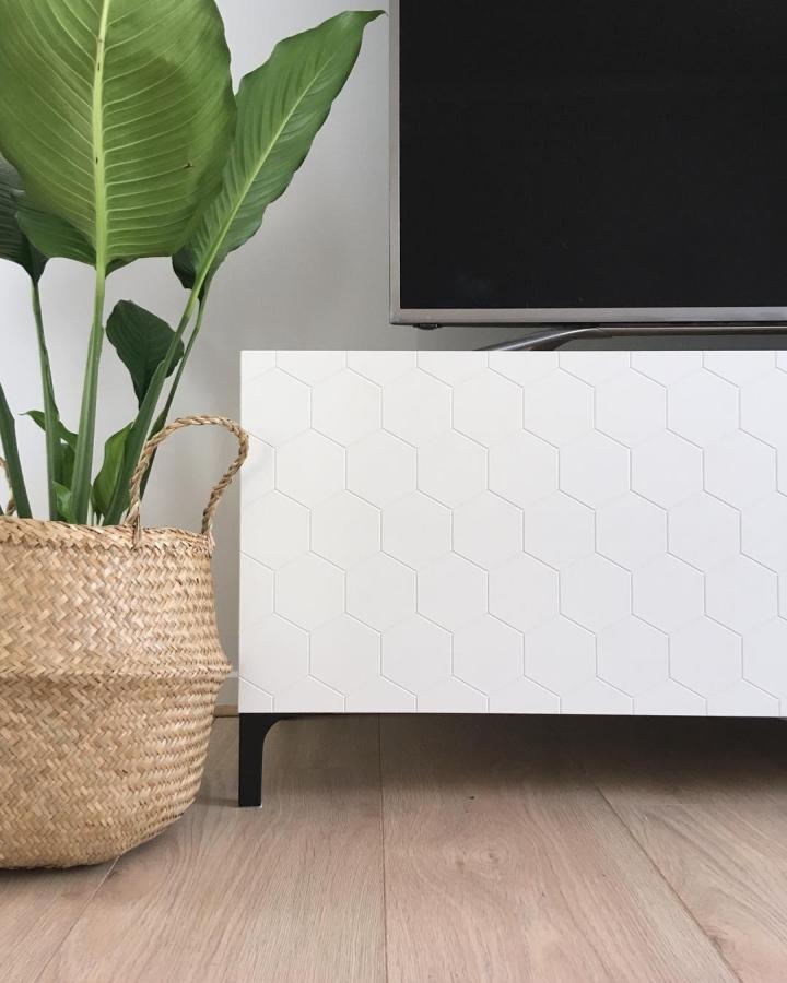 White geometric patterned cabinet showcasing ikea media center hacks & ideas from @the.bray.lj.build with gold hexagon details.