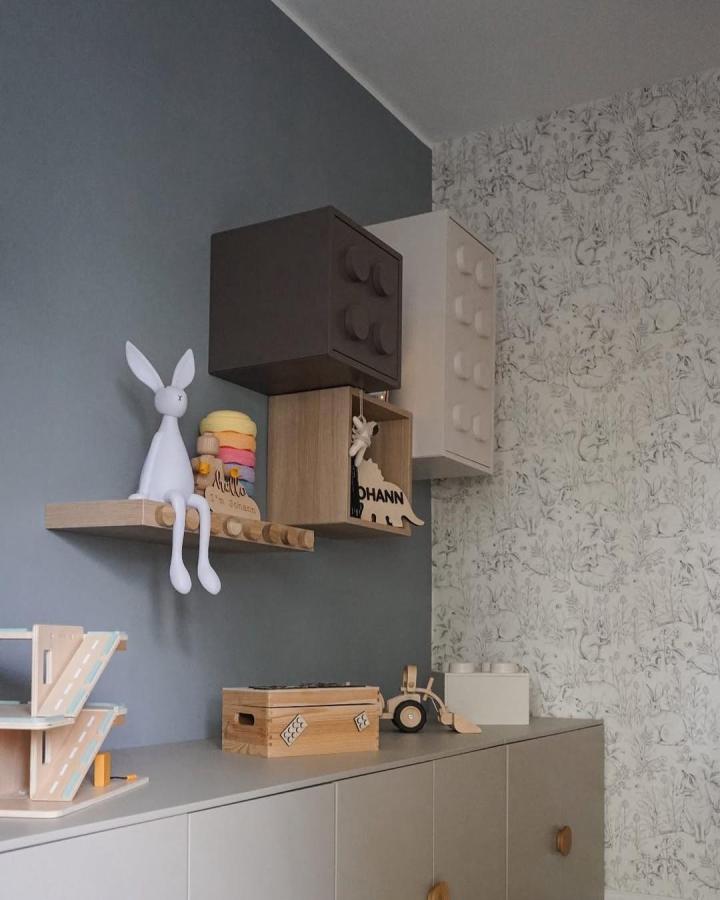 Mixed material nursery wall storage from @_christelle____. Eket cubes and natural wood shelves on blue wall.