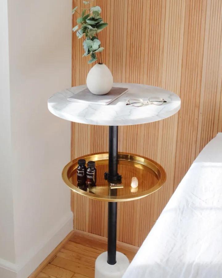 Marble and brass two-tier nightstand from @malcolmsimmons. Ikea lazy susan and tray stacked vertically.