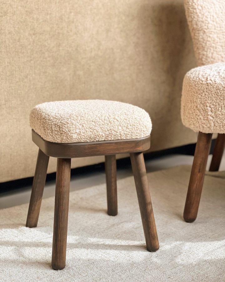 Cream boucle upholstered stool from @dalia.ea showcasing ikea anthropologie hacks & ideas with wooden legs and textured fabric