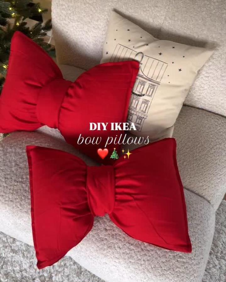 Red fabric bow cushions from @eikhaugen_ arranged with printed holiday pillows on grey sofa.