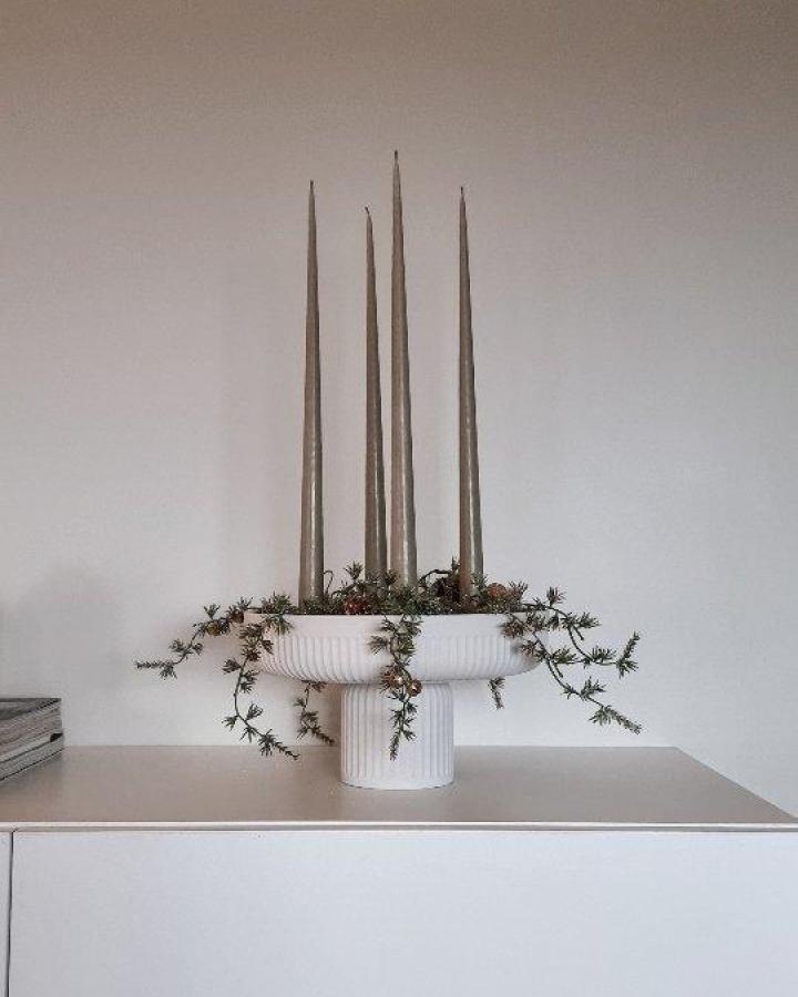 White plaster-painted glass vessels from @tidforendring. Tall tapered candles with pine cone and evergreen accents.