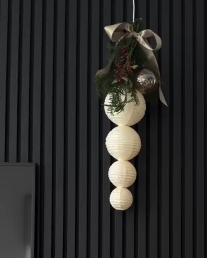 White stacked pendant lamp cluster from @weil_ichs_can with greenery, berries, and cream ribbon detail.